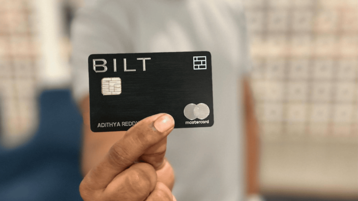 A man holding out the Bilt Rewards Mastercard.
